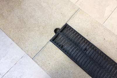 Mini channel drain used for tiled patio. D&F Plumbing, Heating and Cooling provides professional patio and deck drain cleaning services in the Portland, OR and Vancouver, WA areas.