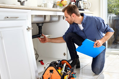 Man inspecting underneath sink. D and F Plumbing serving Portland OR and Vancouver WA talks about the importance of a plumbing inspection for new homeowners.