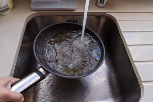Grease in pan with running water. D & F Plumbing serving Portland OR & Vancouver WA debunks the top plumbing myths.