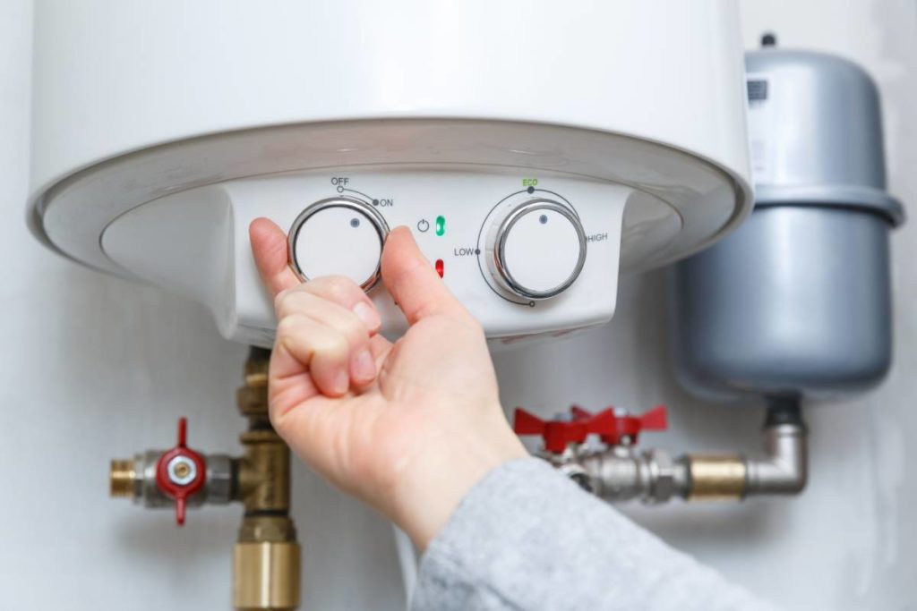 Person adjusting the settings on their water heater tank