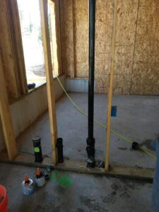 interior shot of new home under construction showing newly installed plumbing pipes