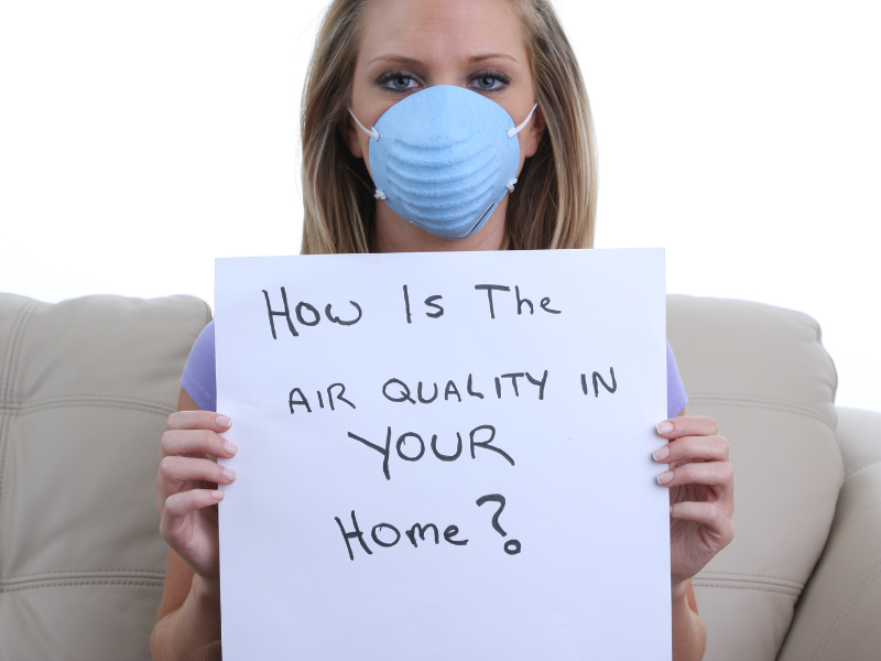 Woman with sign asking "How is the air quality in your home?"