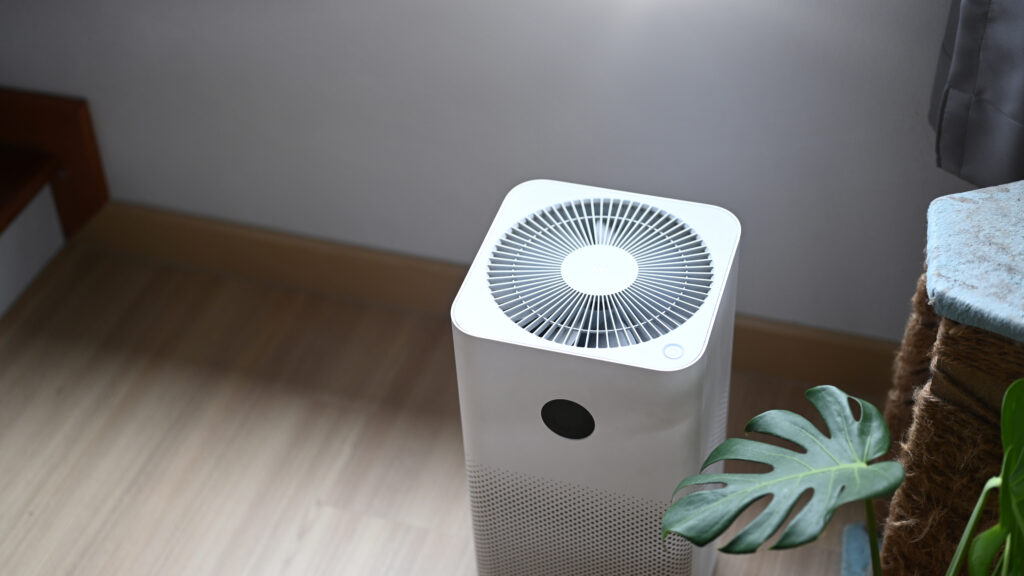 Air purifier in comfortable living room with house plant on the