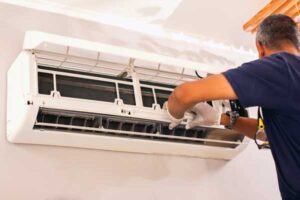 Man repairing an indoor AC mini-split unit