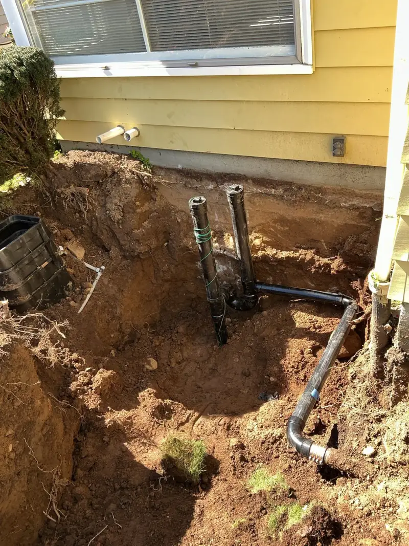 Rain drain line newly tied in beside a Portland house during a D&F job
